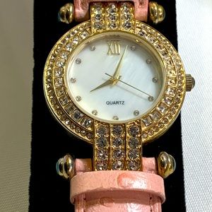 Pink genuine leather, ostrich style band with gold and crystal lined watch face